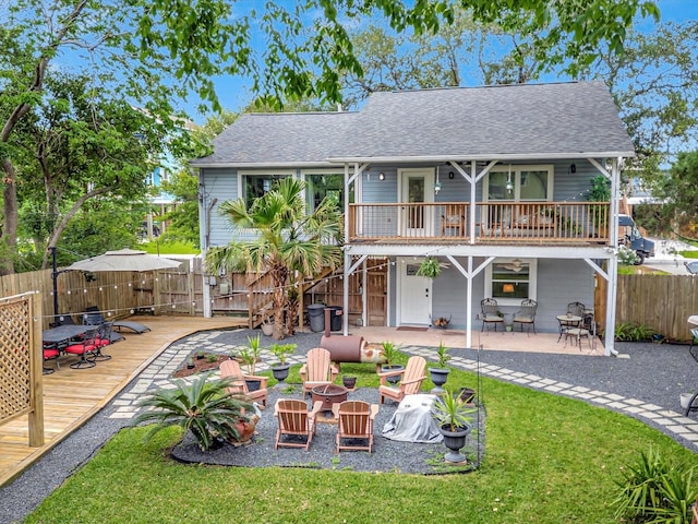 1002 Staples Ave, Seabrook, TX 77586 - back of house featuring an outdoor fire pit, a wooden deck, a shingled roof, and a patio