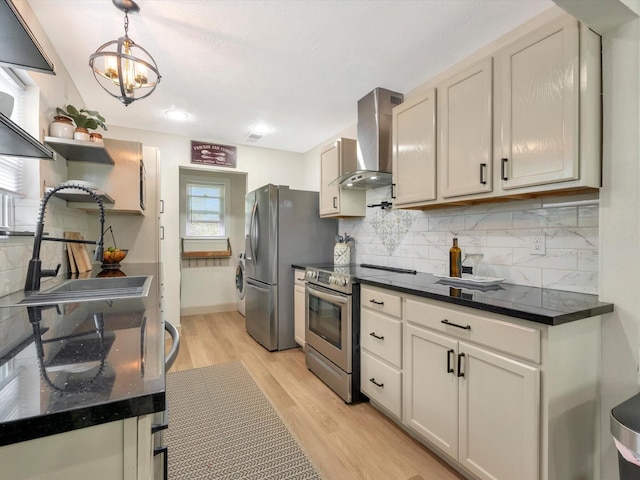 1002 Staples Ave, Seabrook, TX 77586 - kitchen featuring wall chimney range hood, appliances with stainless steel finishes, a sink, light wood-style flooring, and decorative backsplash