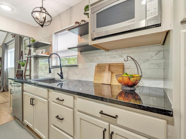 1002 Staples Ave, Seabrook, TX 77586 - kitchen featuring open shelves, stainless steel appliances, a sink, tasteful backsplash, and a chandelier