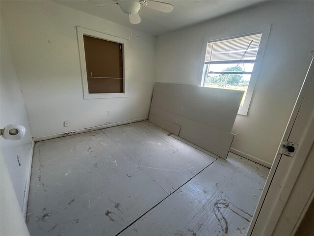 empty room featuring a ceiling fan and baseboards