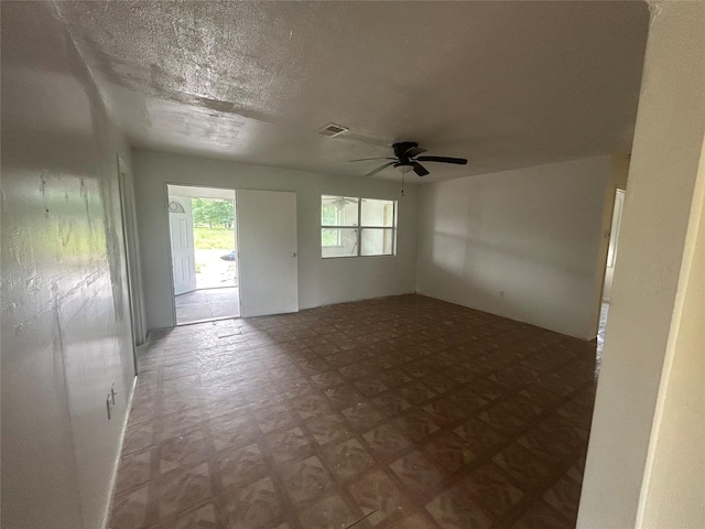 unfurnished room featuring visible vents and ceiling fan