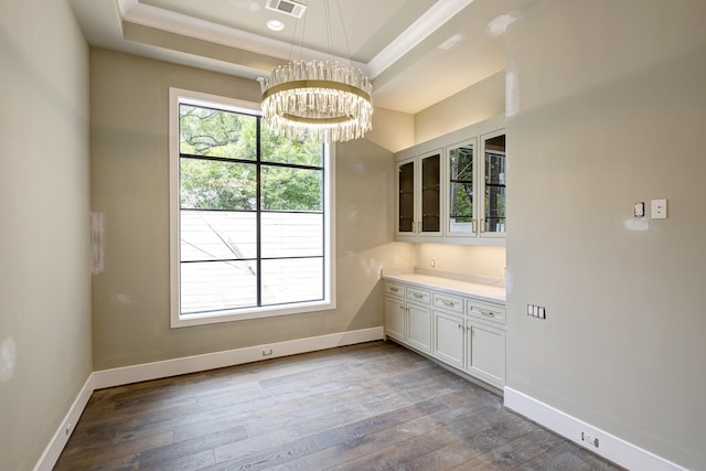 5517 Sturbridge Dr, Houston, TX 77056 - unfurnished dining area featuring a raised ceiling, a chandelier, hardwood / wood-style floors, baseboards, and ornamental molding
