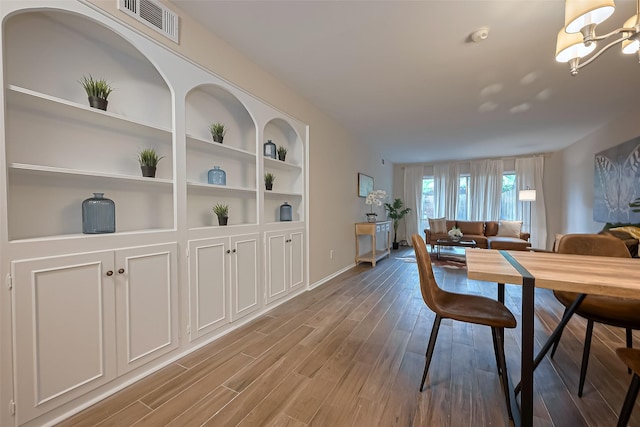 859 Wax Myrtle Ln, Houston, TX 77079 - dining room with wood finished floors, visible vents, an inviting chandelier, and built in features