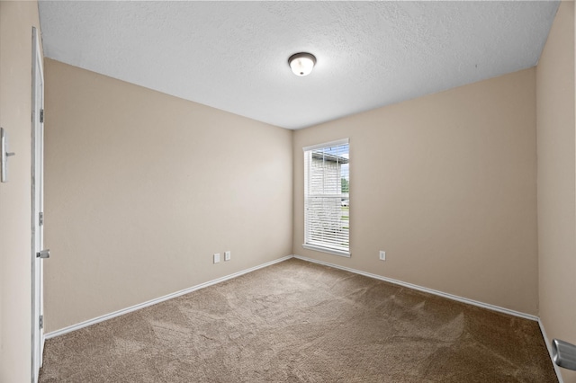 carpeted spare room with baseboards and a textured ceiling