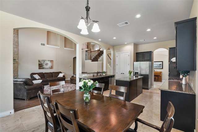 dining area featuring arched walkways, an inviting chandelier, visible vents, and recessed lighting