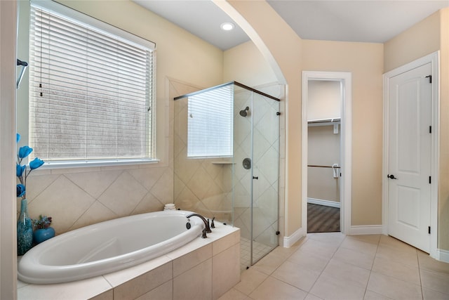 full bathroom with a shower stall, a garden tub, tile patterned flooring, and baseboards
