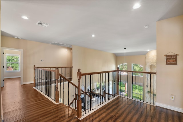 corridor featuring baseboards, visible vents, recessed lighting, an upstairs landing, and wood finished floors