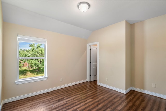 spare room with lofted ceiling, baseboards, and wood finished floors