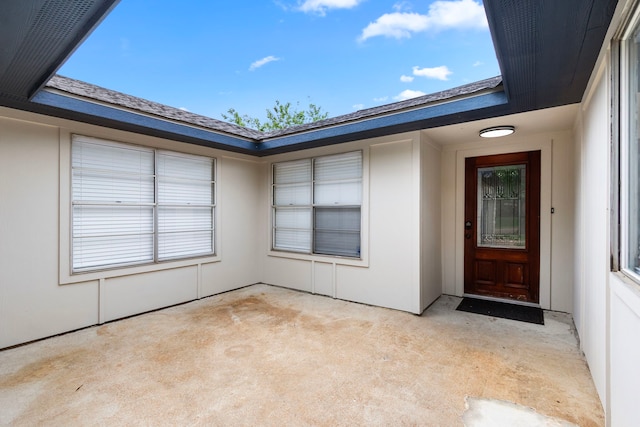 view of exterior entry with a patio