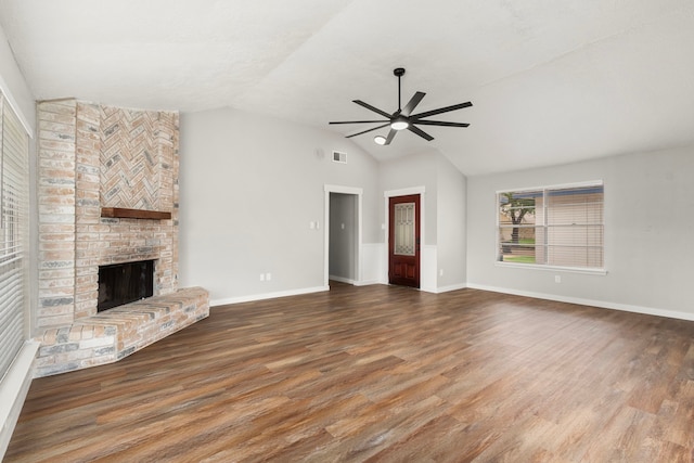 unfurnished living room featuring visible vents, a brick fireplace, wood finished floors, ceiling fan, and vaulted ceiling