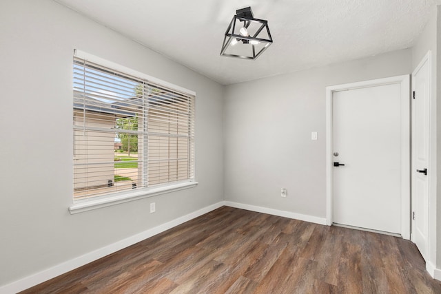 unfurnished room with baseboards and wood finished floors