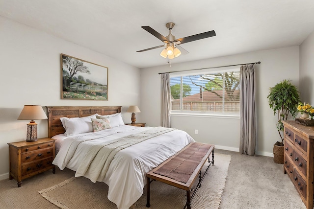 bedroom with light colored carpet, baseboards, and ceiling fan