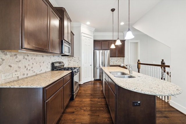 kitchen with a sink, stainless steel appliances, dark brown cabinets, dark wood finished floors, and a center island with sink