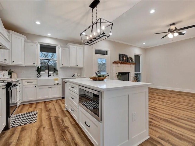 282 Lancewood Cir, Hudson, TX 75904 - kitchen featuring tasteful backsplash, a sink, white cabinets, black electric range, and stainless steel microwave