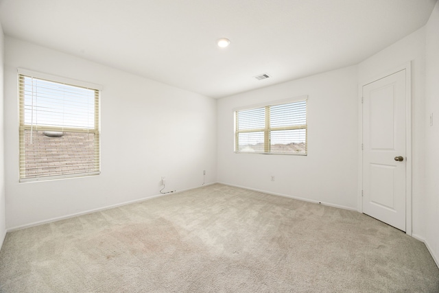 unfurnished room with light carpet, baseboards, and visible vents