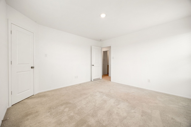 unfurnished bedroom featuring baseboards, light carpet, and recessed lighting