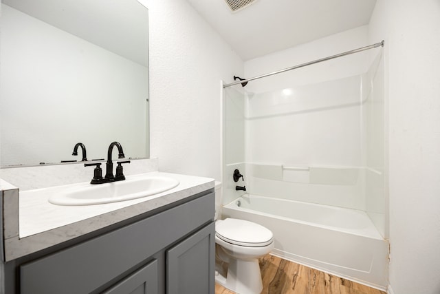 full bathroom with wood finished floors, vanity,  shower combination, toilet, and visible vents