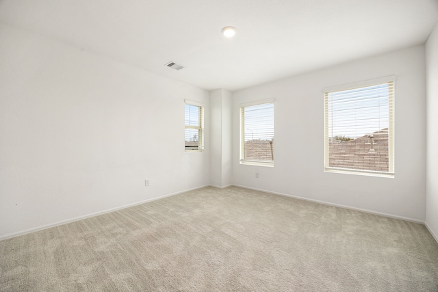 unfurnished room featuring light carpet, baseboards, and visible vents
