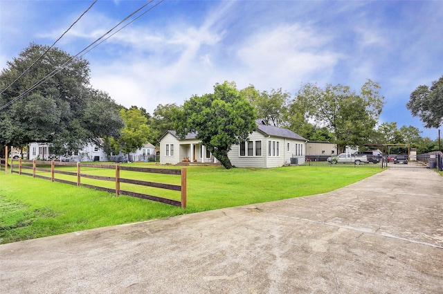 view of front of house with central AC, a front lawn, fence, and driveway