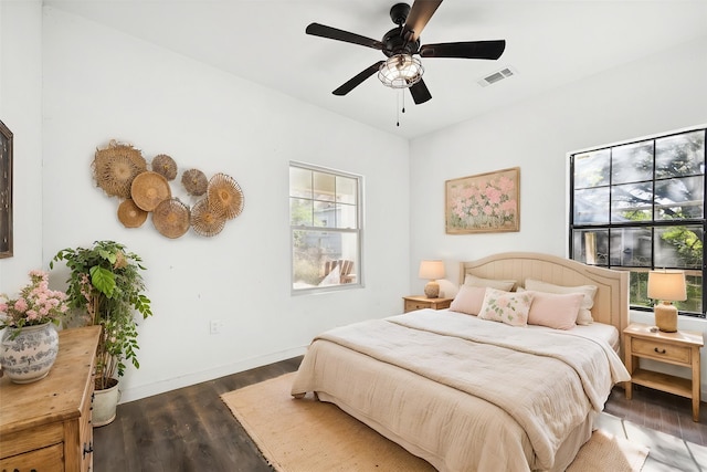 bedroom with baseboards, a ceiling fan, wood finished floors, and visible vents