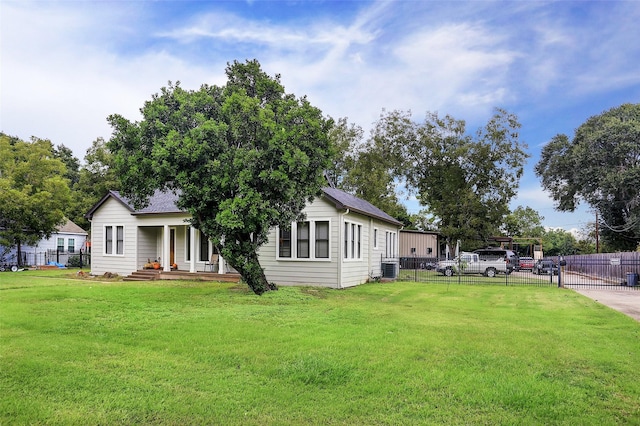 view of front of house featuring a front yard, a porch, fence, and central air condition unit