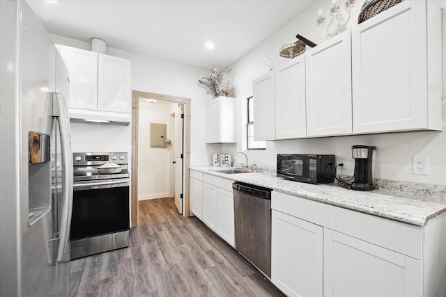 kitchen with a sink, under cabinet range hood, light wood-type flooring, stainless steel appliances, and white cabinetry