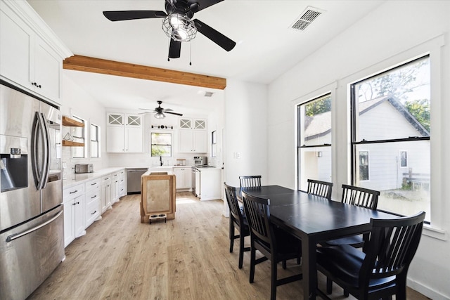 dining room featuring beamed ceiling, visible vents, light wood finished floors, and ceiling fan
