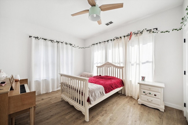 bedroom featuring ceiling fan, light wood-style floors, and visible vents