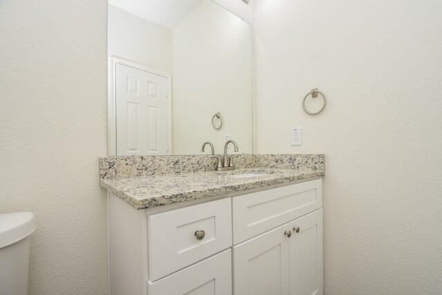 half bathroom with toilet and vanity