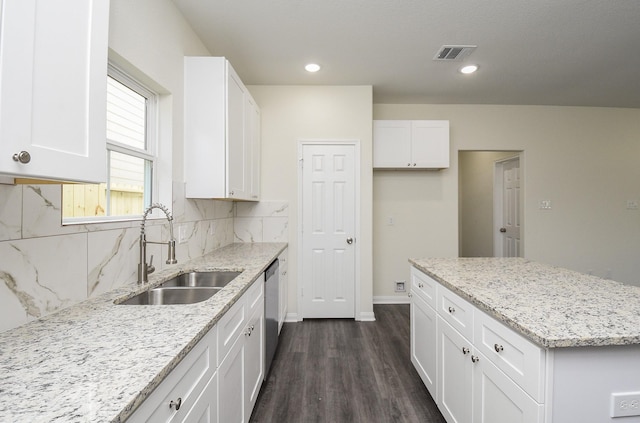 kitchen featuring stainless steel dishwasher, a sink, white cabinetry, and dark wood-style flooring
