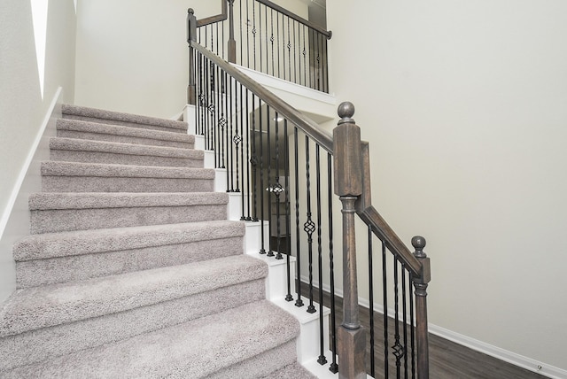 staircase featuring baseboards and wood finished floors