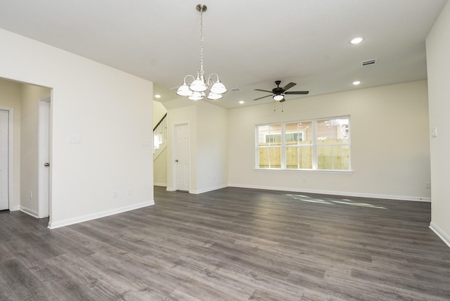 empty room with dark wood finished floors, ceiling fan with notable chandelier, visible vents, and recessed lighting