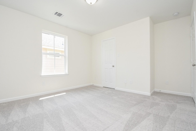 spare room with light carpet, baseboards, and visible vents