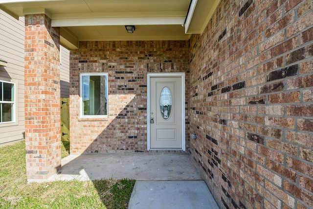 view of exterior entry featuring brick siding