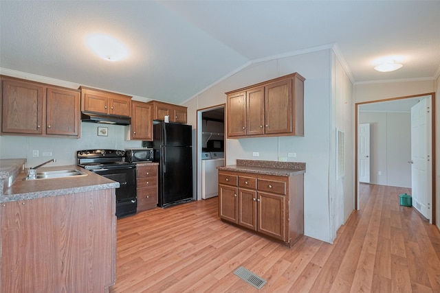 kitchen with light wood finished floors, a sink, visible vents, under cabinet range hood, and black appliances