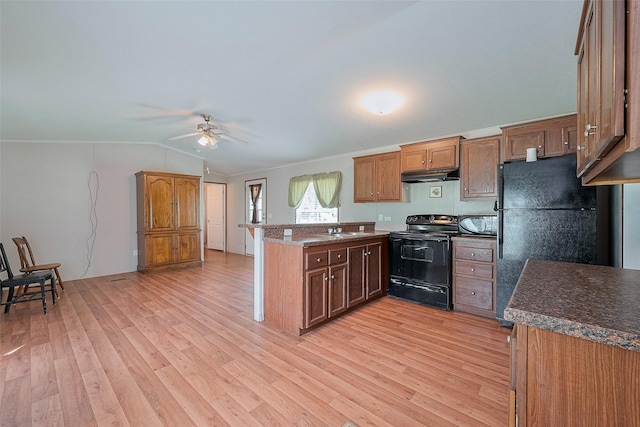 kitchen featuring under cabinet range hood, vaulted ceiling, a ceiling fan, black appliances, and a peninsula