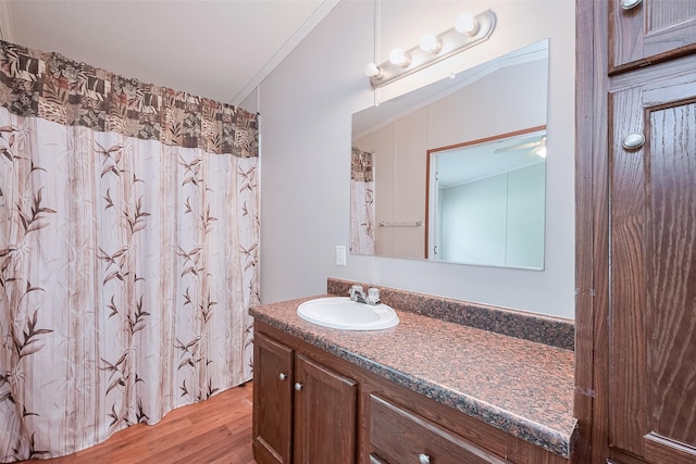 full bathroom featuring a shower with shower curtain, wood finished floors, vanity, and ceiling fan