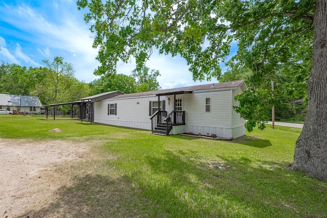 back of house with a carport and a yard