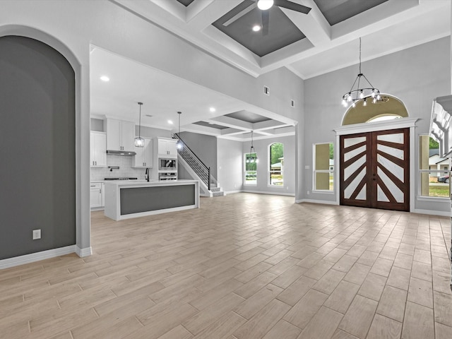 549 Rd 660, Dayton, TX 77535 - unfurnished living room with coffered ceiling, a healthy amount of sunlight, and ceiling fan with notable chandelier
