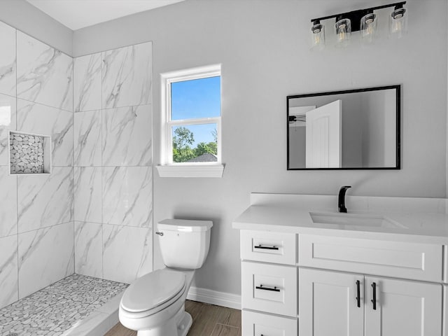 549 Rd 660, Dayton, TX 77535 - bathroom featuring a tile shower, toilet, baseboards, wood finished floors, and vanity