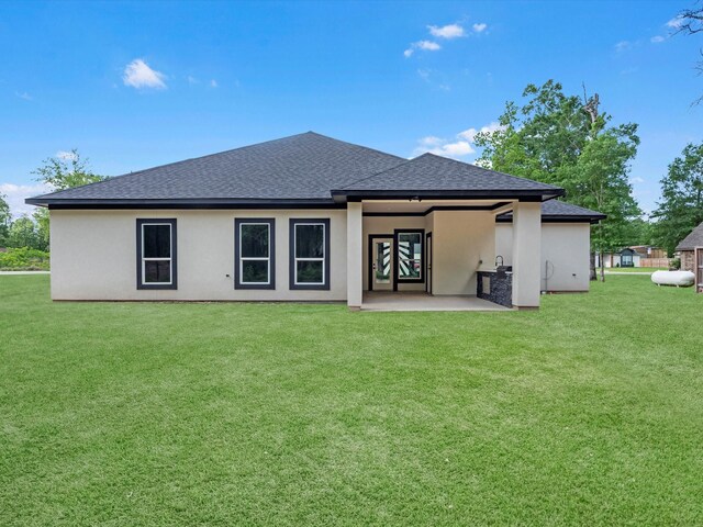 549 Rd 660, Dayton, TX 77535 - rear view of house featuring a patio area, a lawn, a shingled roof, and stucco siding