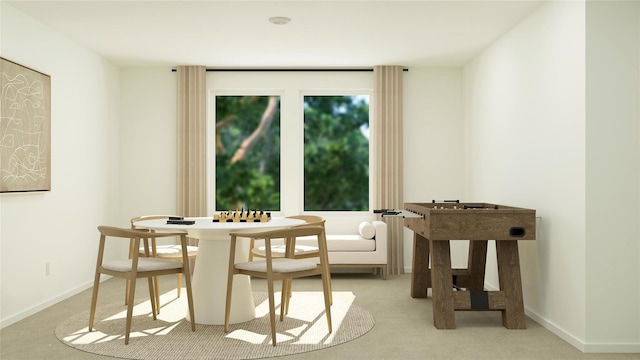 dining area featuring light carpet and baseboards
