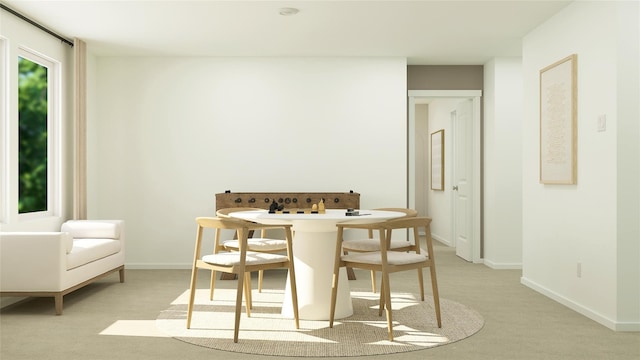 dining space featuring light carpet and baseboards