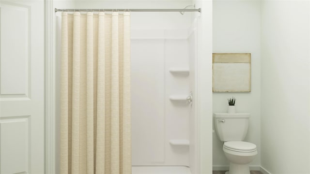 full bathroom with toilet and a shower with shower curtain
