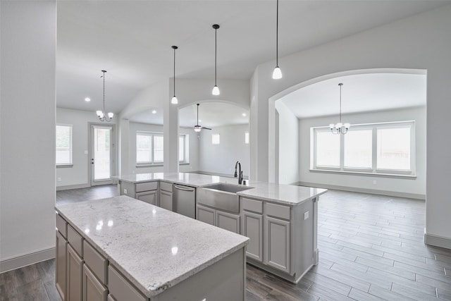 kitchen with open floor plan, stainless steel dishwasher, a sink, and a center island with sink