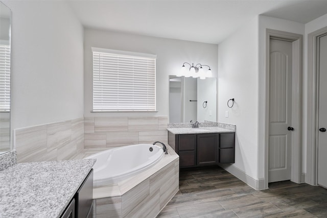 full bath featuring a garden tub and vanity
