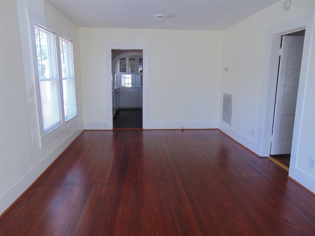 4620 Oak Ridge St, Houston, TX 77009 - spare room with baseboards, arched walkways, dark wood-style flooring, and visible vents