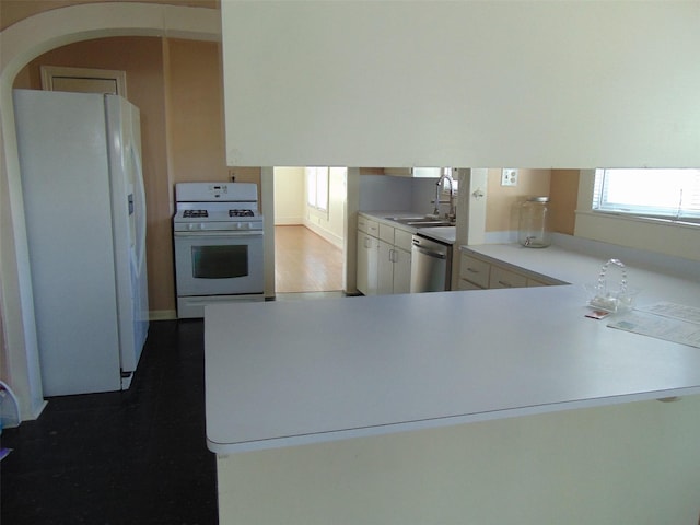 4620 Oak Ridge St, Houston, TX 77009 - kitchen featuring a peninsula, wood finished floors, white appliances, light countertops, and a sink