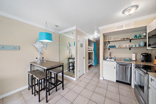 6300 Seawall Blvd Unit 9104, Galveston, TX 77551 - kitchen featuring a sink, light tile patterned floors, white cabinets, appliances with stainless steel finishes, and visible vents
