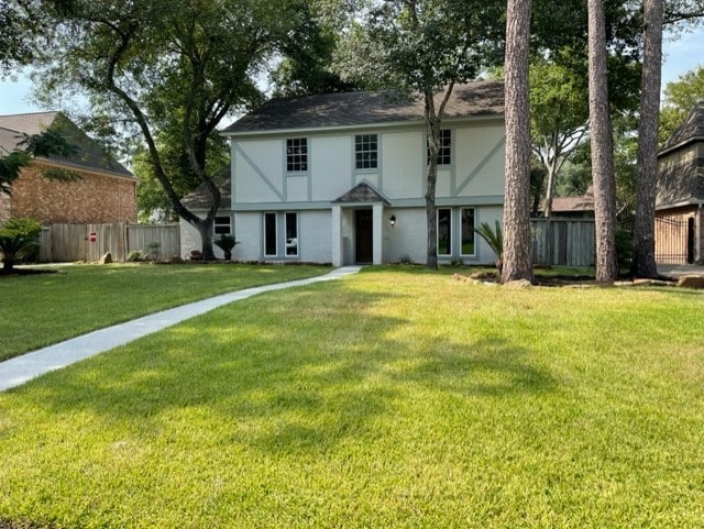 view of front facade featuring a front lawn, fence, and stucco siding